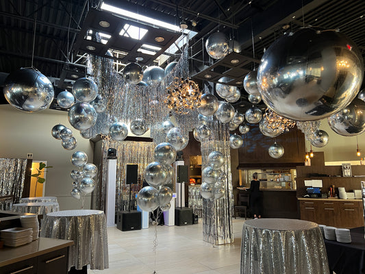 Luxury ceiling balloon installation with silver chrome balloons and metallic streamers for an upscale event