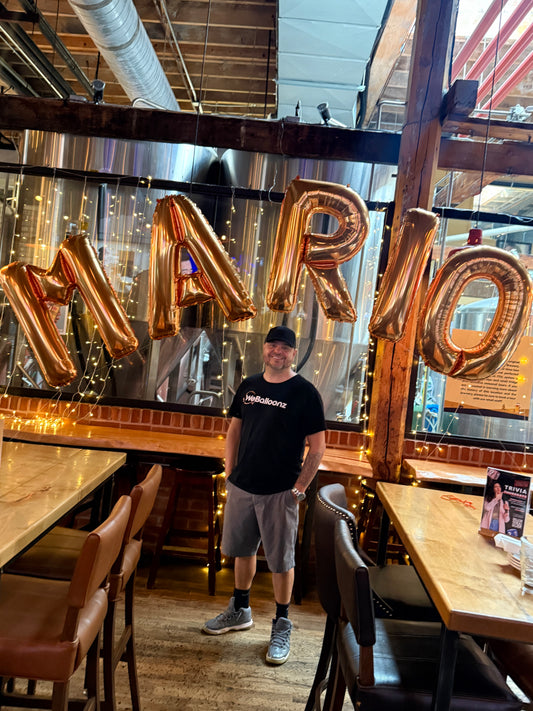 Custom 34 inch gold foil balloon letter arch spelling 'MARIO' for a luxury event installation in Vaughan by WeBalloonz.