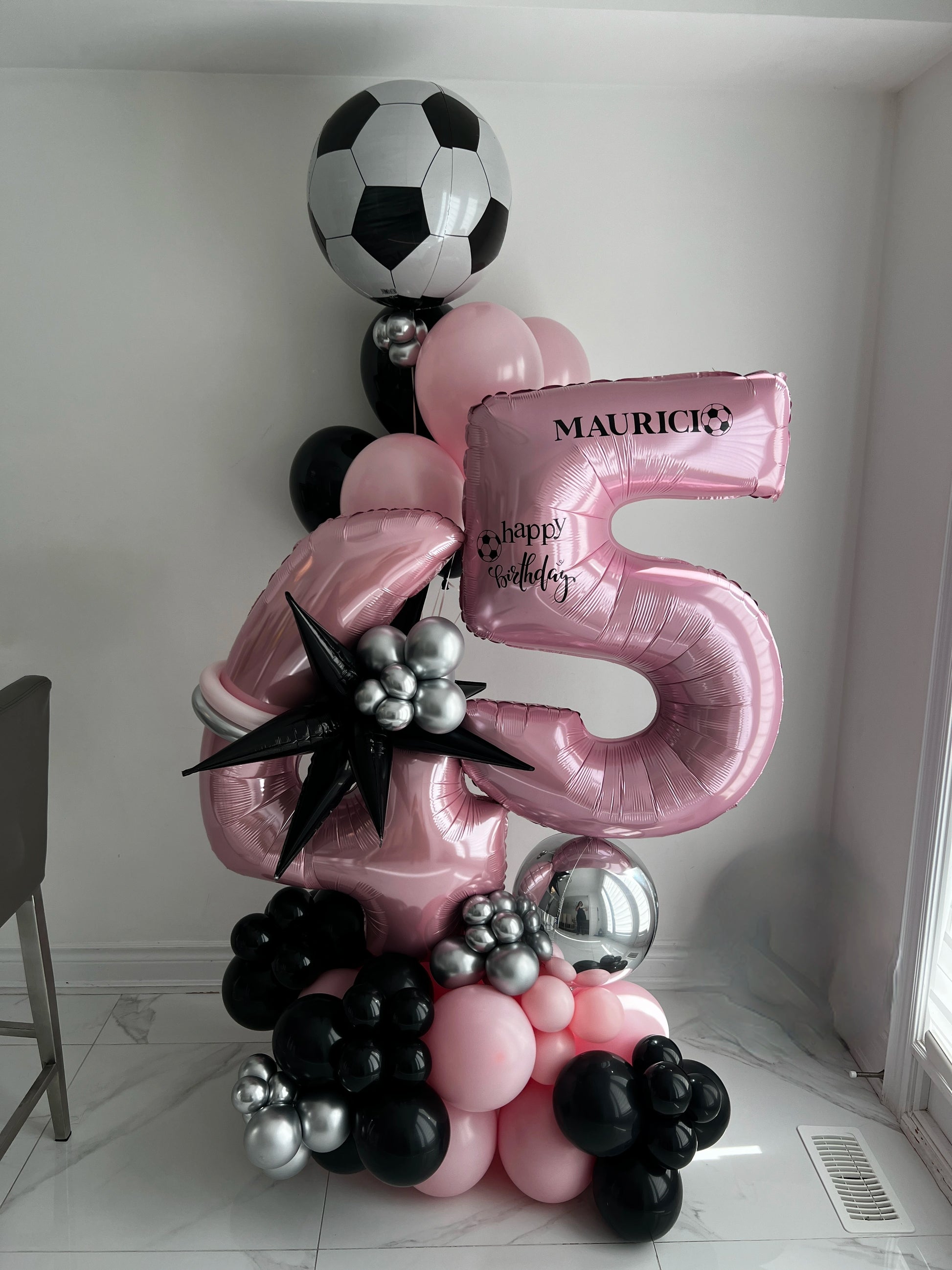 5ft birthday balloon arrangement with pink number 45, soccer ball foil balloon, custom name, and black, pink, and silver balloons