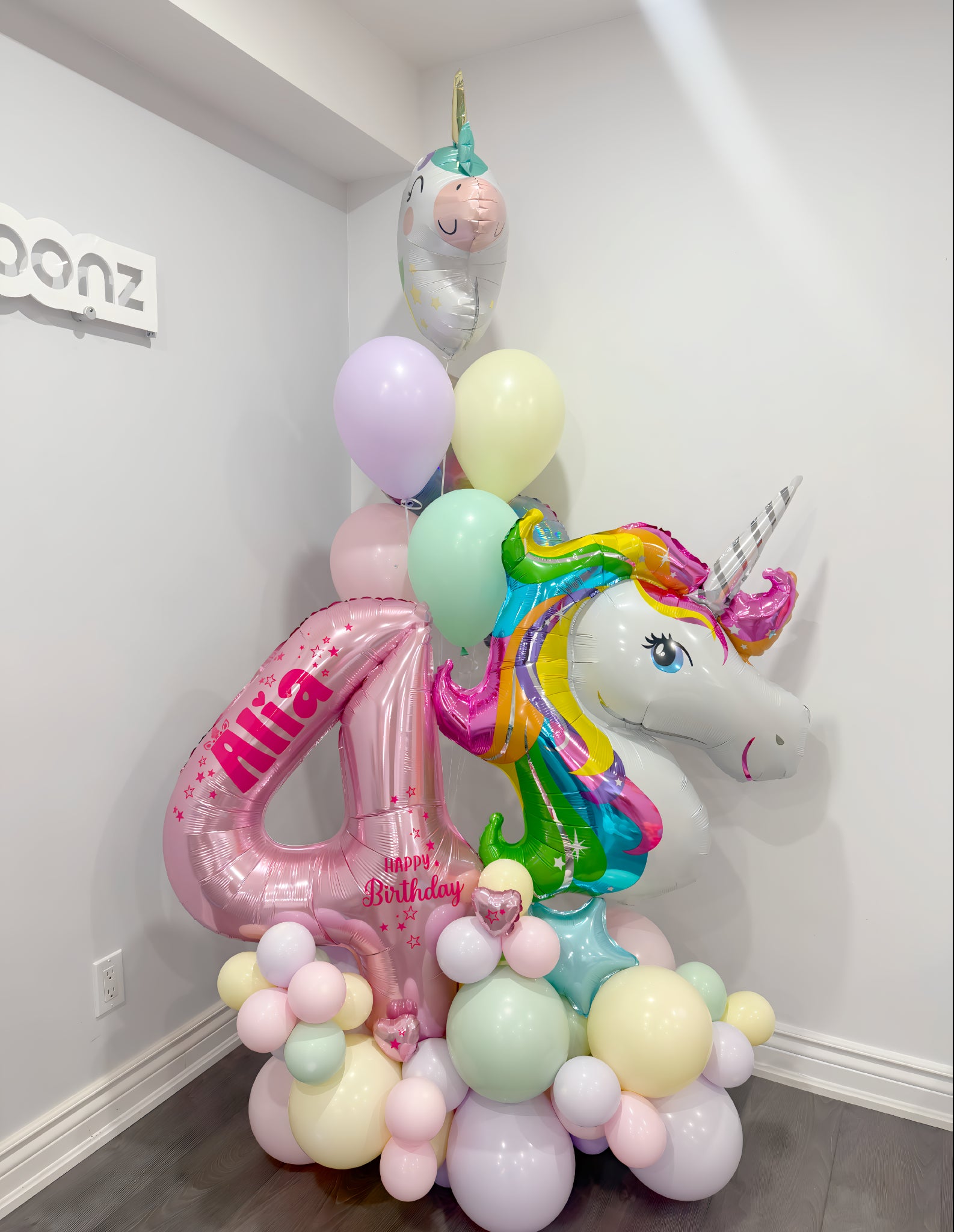 5ft birthday balloon arrangement with pink number 4, unicorn foil balloon, helium bouquet, and pastel balloons customized with name