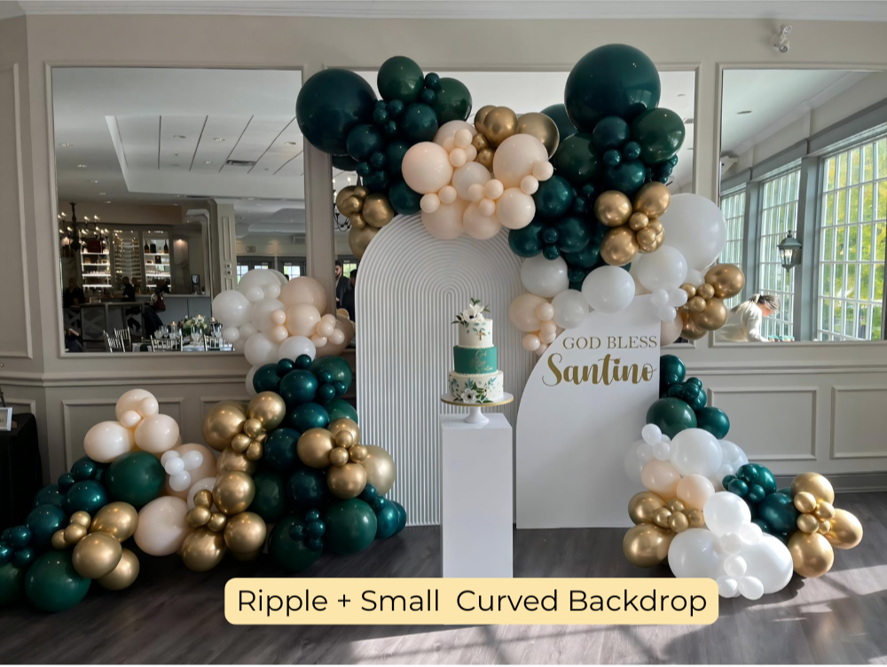 Elegant christening balloon decor with green, white, and gold garland, ripple panel, and mini curved arch with personalized ‘God Bless Santino’ sign