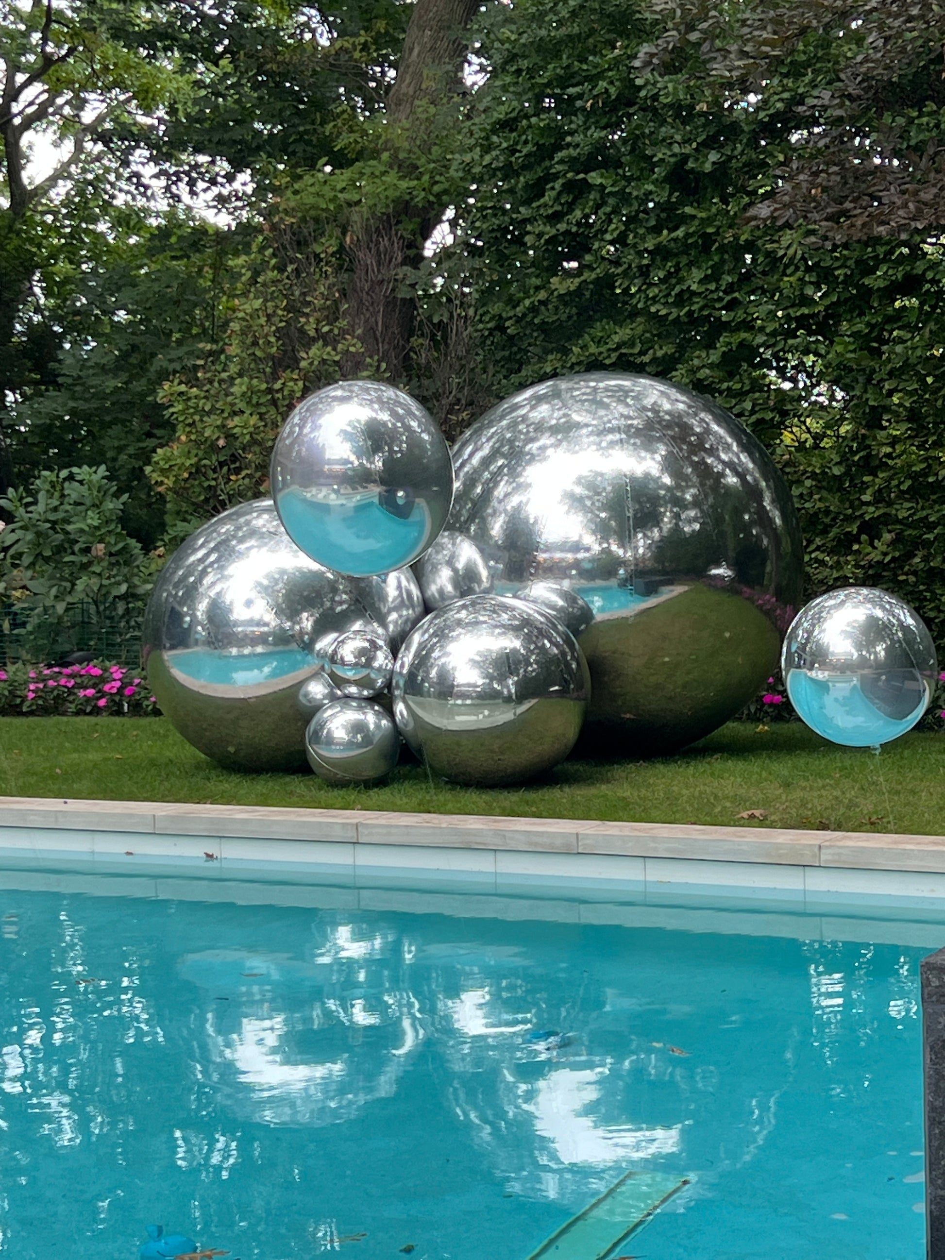 Giant chrome silver balloon sculpture by the pool for luxury outdoor corporate or private event