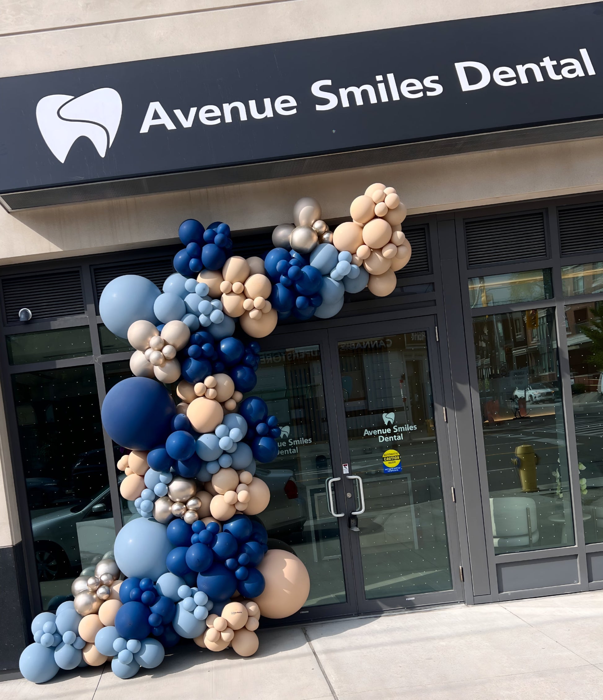 Balloon garland in navy blue, beige, and silver at Avenue Smiles Dental corporate storefront event