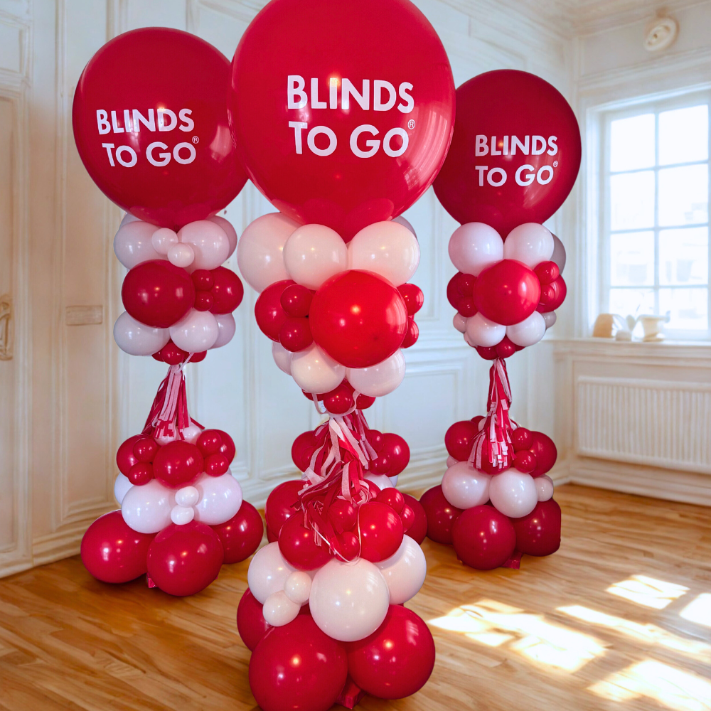Red and white corporate balloon towers with custom Blinds To Go logo balloons for brand activation