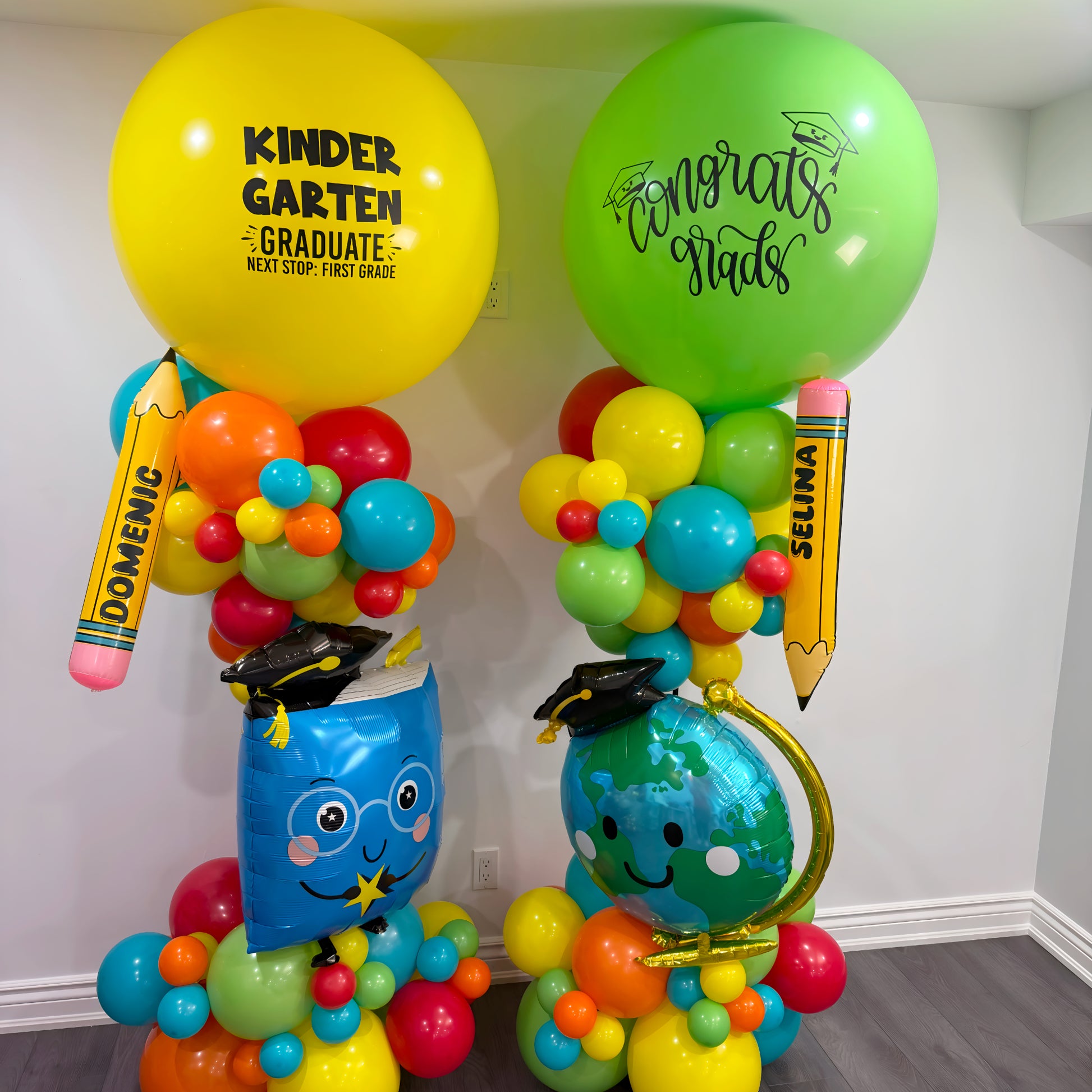 Kindergarten graduation balloon towers with colorful balloons, personalized jumbo balloons, pencil foils, and character balloons wearing graduation caps