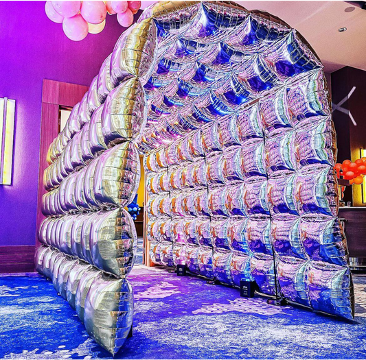 Professional 18ft silver foil walk-through balloon tunnel installation for a luxury corporate entrance in Vaughan by WeBalloonz, featuring an immersive architectural design.