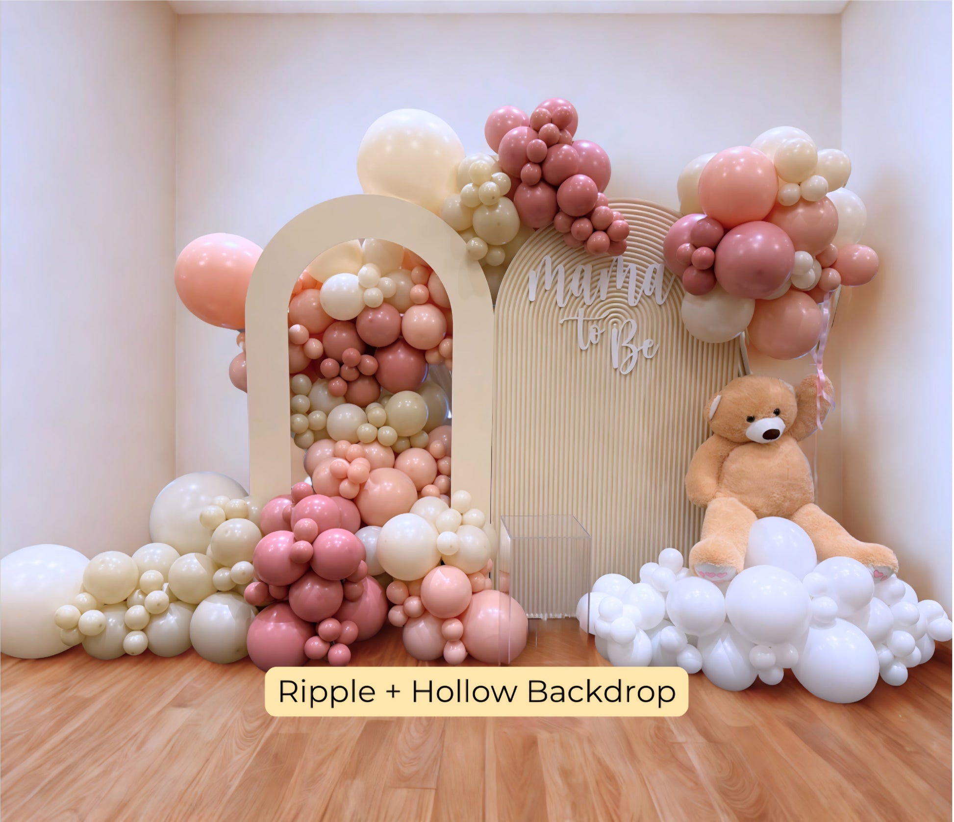 Elegant blush and cream balloon garland with arch panels and teddy bear for a luxury “Mama to Be” baby shower setup.