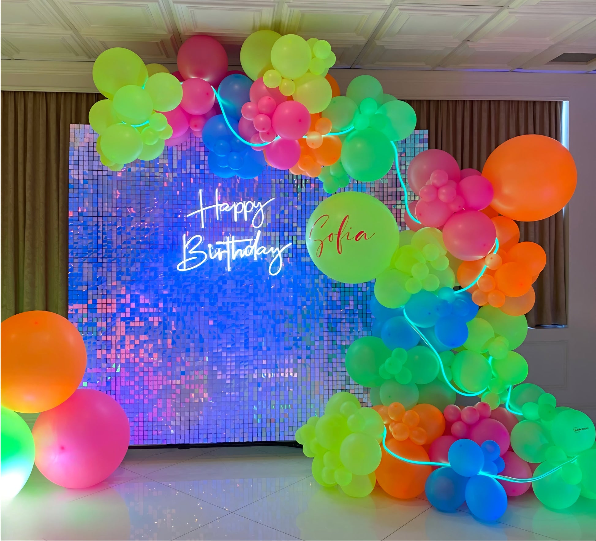Neon balloon garland with glow effect and sequin backdrop for Sofia’s birthday celebration