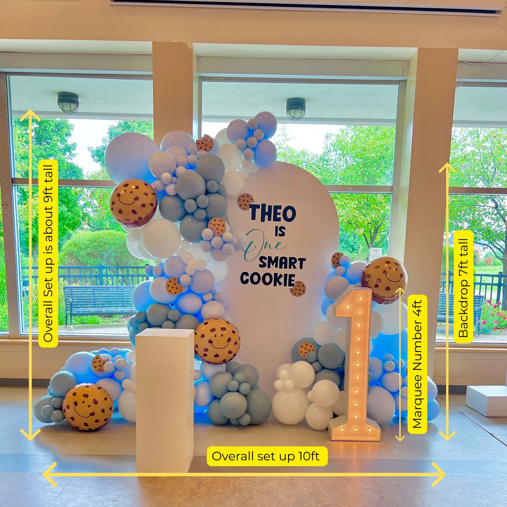 One Smart Cookie birthday balloon garland setup with size dimensions — includes 7ft backdrop, 4ft marquee number, and total width of 10ft.