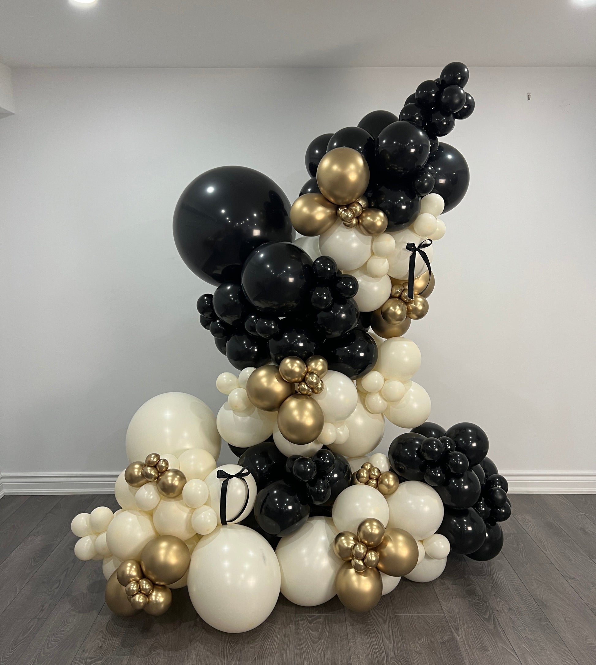 Black, white, and gold stand-alone organic balloon garland perfect for elegant events or celebrations